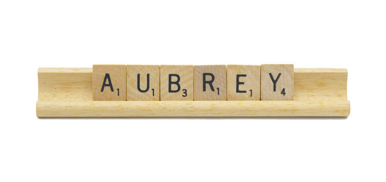 Miami, FL 4-18-24 popular baby girl first name of AUBREY made with square wooden tile English alphabet letters with natural color and grain on a wood rack holder isolated on white background