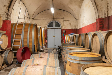 Wooden barrels and barriques in a cellar where the famous Italian red wine typical of Tuscany is produced
