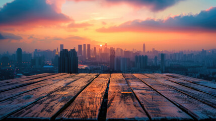 Empty wooden table top with view of city skyline and colorful sky at sunset