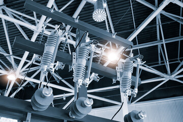 A series of electrical wires are suspended from the ceiling. The wires are connected to a power source and are likely used to transmit electricity - Powered by Adobe