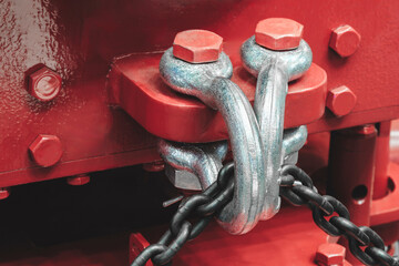 A red object with a chain and a bolt on it