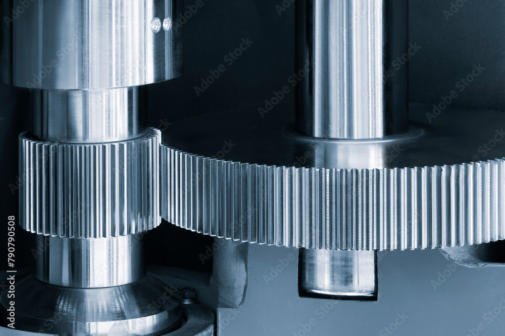 Poster a close up of a machine with gears and a metal casing. the gears are silver and the casing is also s