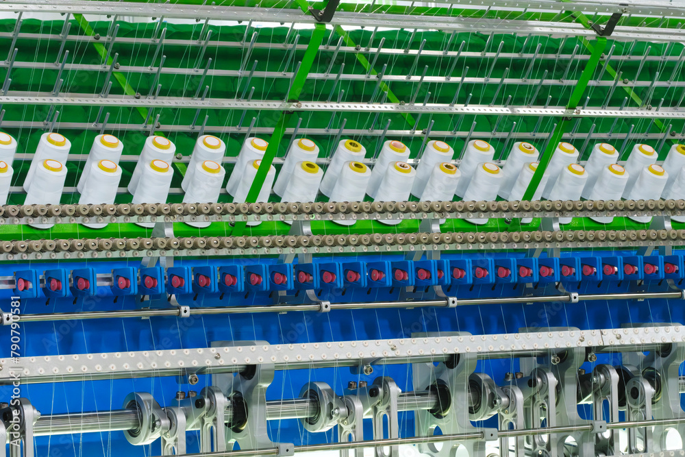 Leinwandbilder A machine is weaving a fabric with many different colored threads. The machine is blue and white