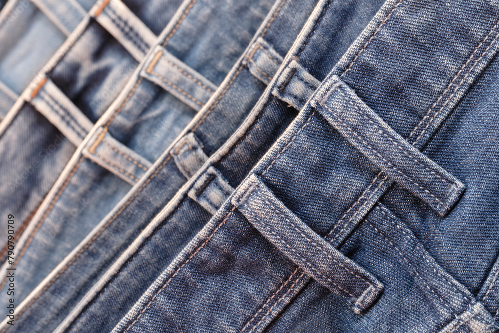 Leinwandbilder a row of jeans with different colors and patterns. the jeans are hanging on a rack