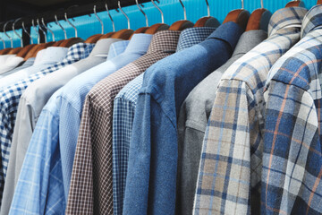 A rack of clothes with a blue shirt on the top