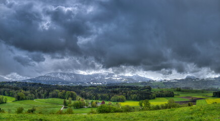 Wintereinbruch im Frühling mit schneebedeckten Bergen und grünen Tälern