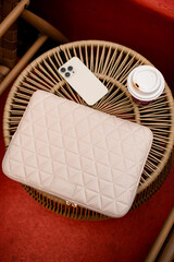 Top view of white laptop bag, smartphone and cup of coffee