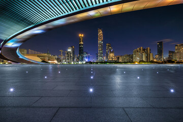 Empty square floors and bridge with modern city buildings at night in Guangzhou