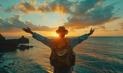 Fototapeta premium man raising arms up enjoying sunset on the beach looking morning sunrise - Self care, traveling, wellness and healthy life style concept