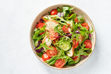 Healthy food. Green salad with baked chicken breast, fresh salad leaves and vegetables. Top view on white background. - 790807991