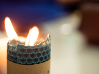 Warm ambiance of glowing wax candles casting flickering light in a serene setting, creating a cozy...