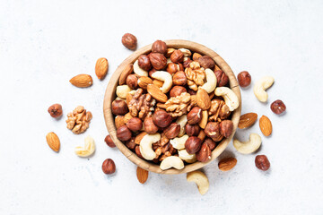 Nuts assortment at white background. Almond, hazelnut, cashew in wooden bowl. Top view