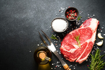 Raw meat steak with spices on black background. Beef steak ribeye. Top view with copy space. - 790812125