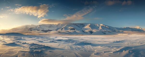 A panoramic vista of a snow-covered mountain range bathed in the golden light of the setting sun, casting long shadows across the landscape. - obrazy, fototapety, plakaty