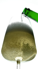Pour sparkling wine or champagne in glass, white background