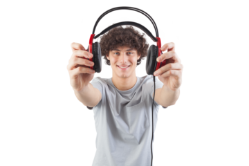 Young handsome smiling man, holding headphones in his hand and showing them to the camera before putting them on to listen to music or play video games, isolated against a white background