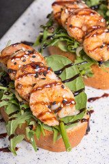 Close up toast with fried shrimp and salad mix. Delicious snacks with seafood