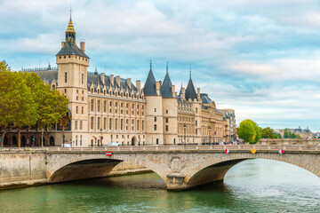 Conciergerie palace with Pont au Change over Seine river in Paris, France. Building of former royal palace and prison. Palais de Justice. Travel destination