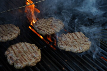 grilled meat burger patties on the grill kissed by a flame