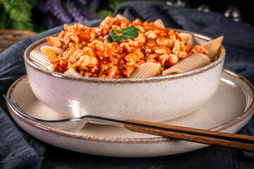 Penne pasta with minced chicken meat in tomato sauce.