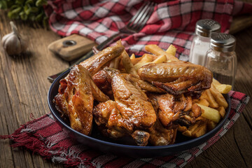 Baked chicken wings with french fries.