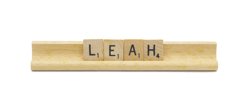 Miami, FL 4-18-24 popular baby girl first name of LEAH made with square wooden tile English alphabet letters with natural color and grain on a wood rack holder isolated on white background