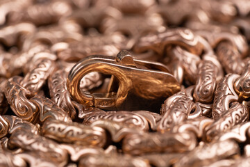 Gold chain closeup background. Rolled gold chain with lock on top.