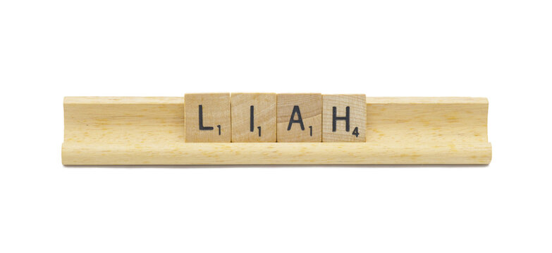 Miami, FL 4-18-24 popular baby girl first name of LIAH made with square wooden tile English alphabet letters with natural color and grain on a wood rack holder isolated on white background