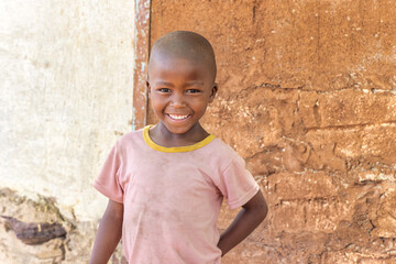 happy village african child, standing in front of the house