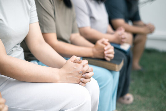 Christian woman held hands with the group, expressing their faith through prayer and devotion to God, uniting in their shared religion. Friends, Group christian pray concept.