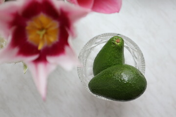 Avocado and flowers on the table top view. Healthy food.