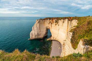 Cliffs and la Manneporte natural arch of Etretat, Normandy, France. French sea coast in Normandie with famous rock formations at sunset. Travel destination - 790882552