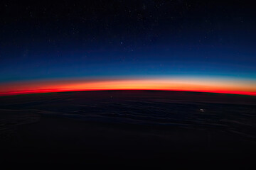 The horizon line, a thin strip of dark blue and red sky at the edge of space