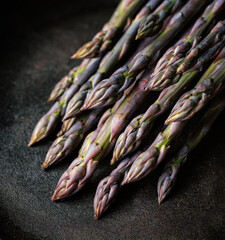 Purple asparagus on a black background, close up view