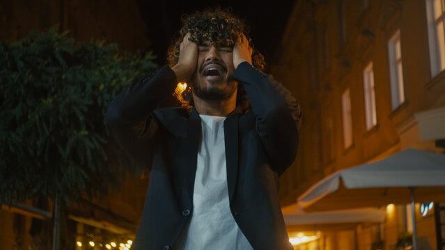 Upset Arabian Latino Indian American man outside city dissatisfied screaming hold head problem failure loss unhappy guy trouble pain crisis despair emotional stress feeling frustration grief sorrow