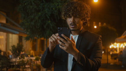 Indian Arabian Latino American man using mobile phone smartphone losing failure bad news messages...