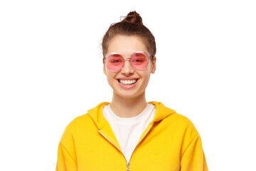 Portrait of young happy teenage girl wearing yellow hoodie and pink glasses, feeling relaxed and...