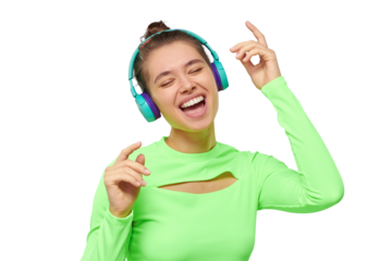 Portrait of teen girl singing and dancing while listening to music in wireless headphones