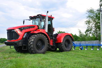 a red tractor with big wheels isolated on the green lawn 
