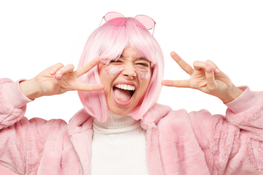 Close-up portrait of young excited funny girl dressed in winter fur coat, showing v sign and enjoying time at party