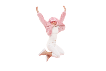 Young happy girl wearing colored funky wig jumping in air, bending knees and lifting hands up