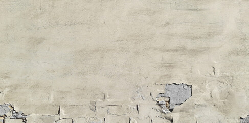 Old and cracked, dilapidated and uneven brick wall with yellowed whitening. Texture and background of faded building wall, painted with whiting. Wavy and bumpy surface in beige color, faded in the sun