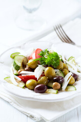 Various olives on white wooden background. Close up. Copy space.	