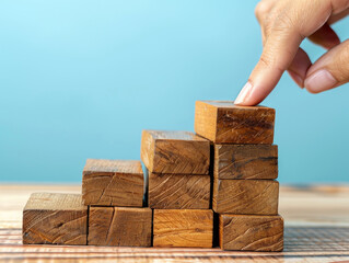 Costruire con successo - impilare a mano i blocchi di legno ,Disporre a mano dei blocchi di legno che salgono come una scala, simboleggiando la crescita e il successo. - obrazy, fototapety, plakaty