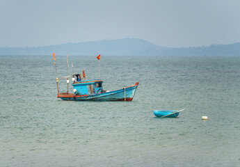 A fishing boat loaded with fishing nets sails on the sea under the flag of Vietnam