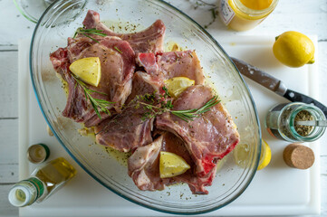 Fresh marinated pork chops with olive oil, lemon, honey, garlic and thyme in a bowl. Delicious...