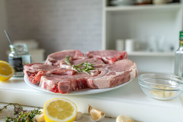 Fresh and raw pork chops on a cutting board in the kitchen. 