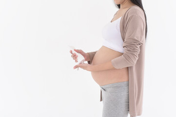 Beautiful pregnant woman applying moisturizing, stretch mark cream on belly, fertility infertility...