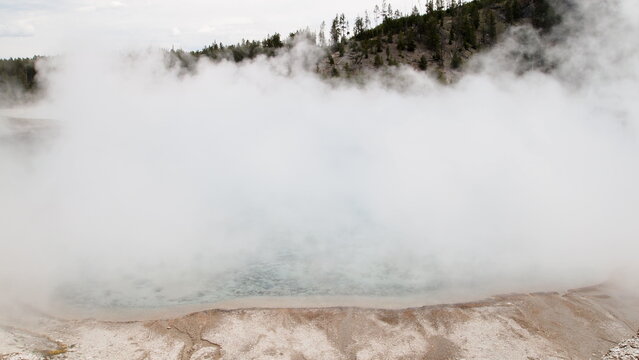 A large thick smoke or steam formed on top of a geothermal spring pool