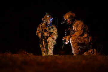 Soldiers in camouflage uniforms aiming with their rifles.ready to fire during Military Operation at...